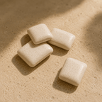White Perli gum pieces arranged on warm stone in morning light