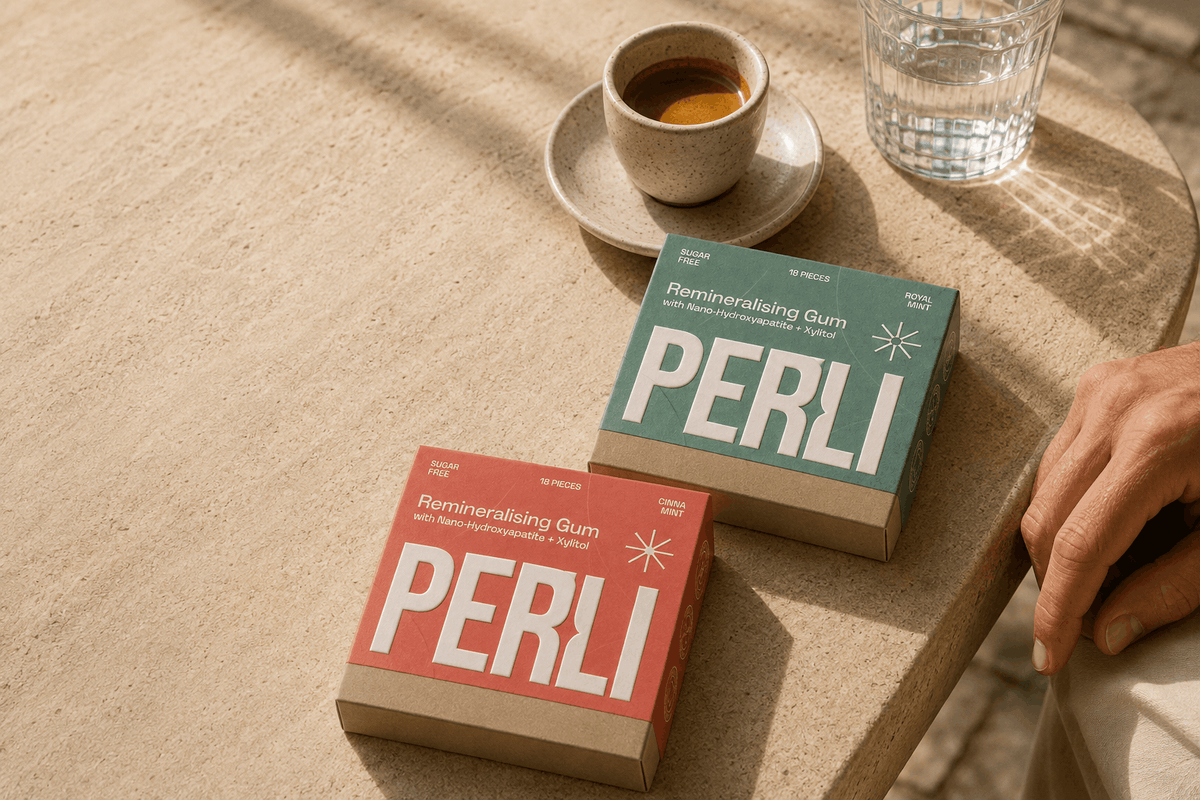 Royal Mint and Cinna Mint packs of Perli remineralising gum beside a coffee